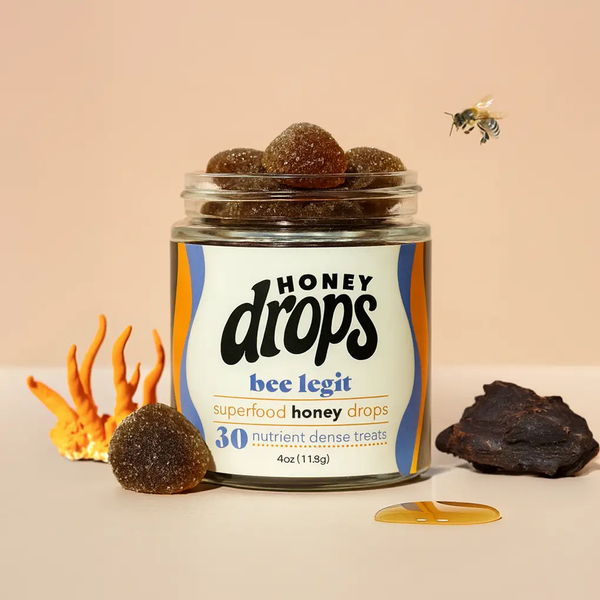 Close-up of Eat Honey Drops Bee Legit honey supplement container with honey drops and bee-themed design.