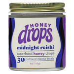 Eat Honey Drops Midnight Reishi supplement bottle with label and lid, showcasing the herbal product in a natural setting.